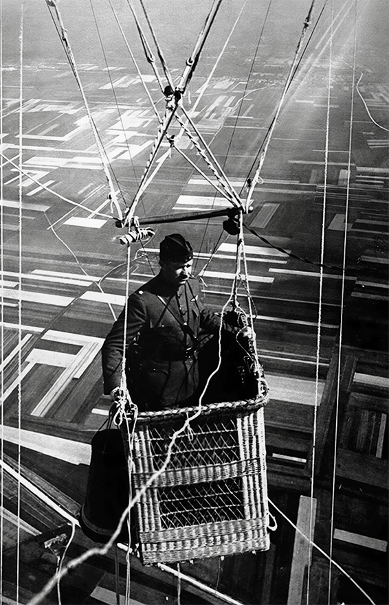 Man riding in a hot air balloon's basket.